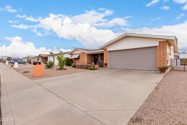 ranch-style house with brick siding, an attached garage, fence, driveway, and a gate