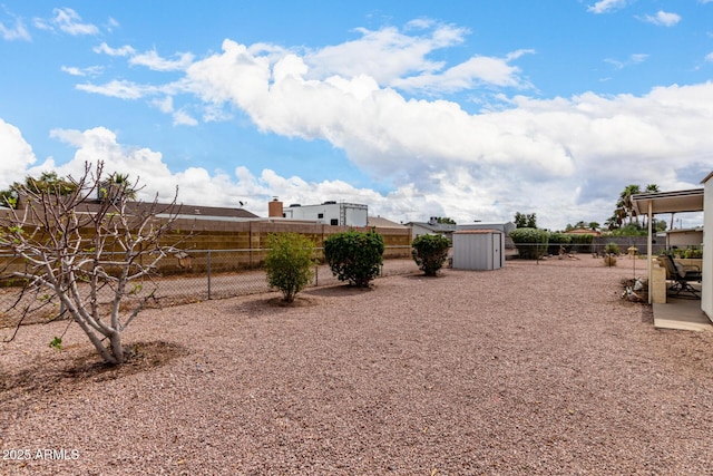 view of yard featuring a storage shed, a fenced backyard, and an outdoor structure