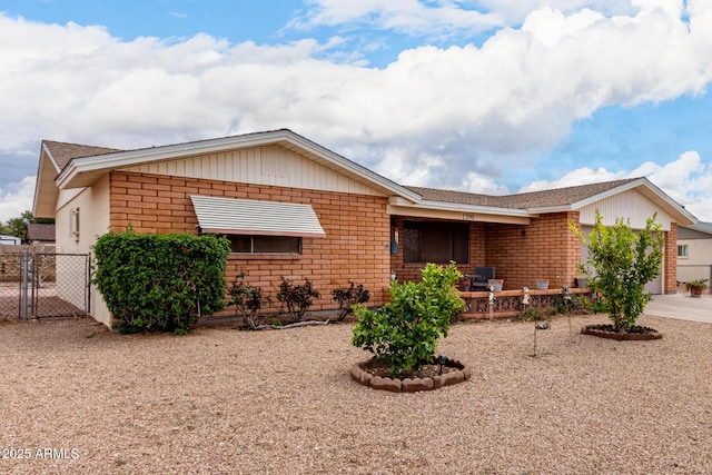 ranch-style home with brick siding, concrete driveway, fence, and a gate