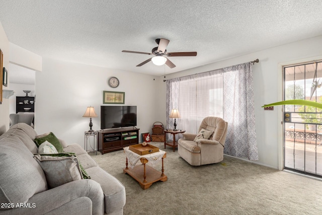 living area featuring carpet floors, a textured ceiling, and a ceiling fan