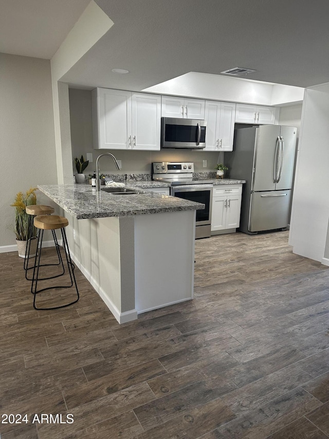 kitchen featuring kitchen peninsula, sink, white cabinets, and stainless steel appliances