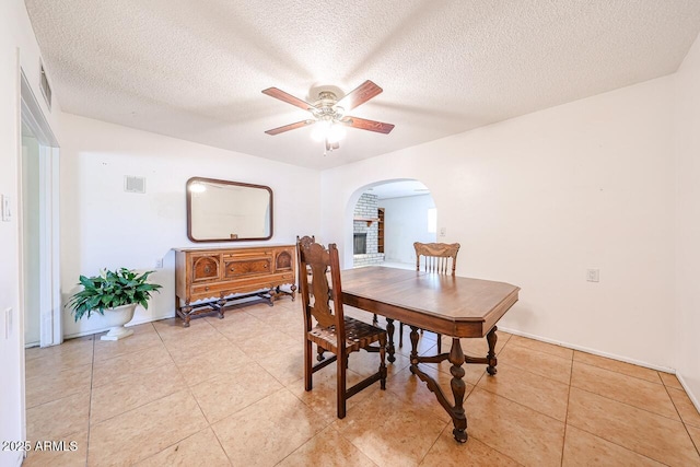 519 N Redondo Dr N, Litchfield Park, AZ 85340 - dining room with arched walkways, ceiling fan, a textured ceiling, and light tile patterned floors
