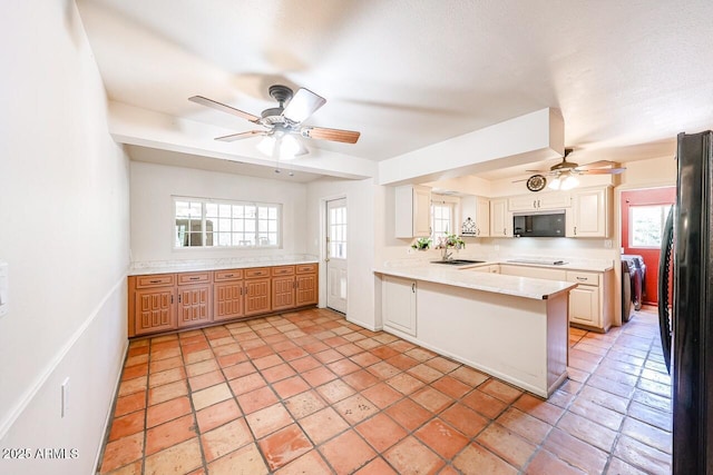 519 N Redondo Dr N, Litchfield Park, AZ 85340 - kitchen with black appliances, a ceiling fan, a peninsula, light countertops, and plenty of natural light