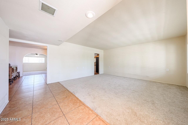 519 N Redondo Dr N, Litchfield Park, AZ 85340 - carpeted spare room with tile patterned floors, arched walkways, and a wood stove