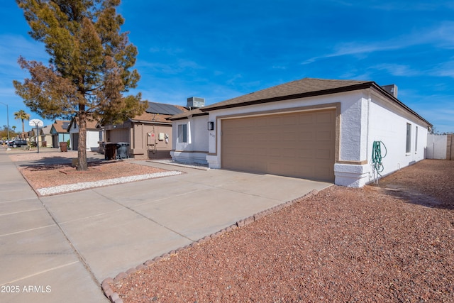 ranch-style house with stucco siding, solar panels, central AC unit, a garage, and driveway