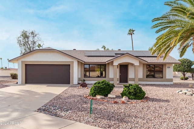 single story home featuring covered porch, a garage, and solar panels