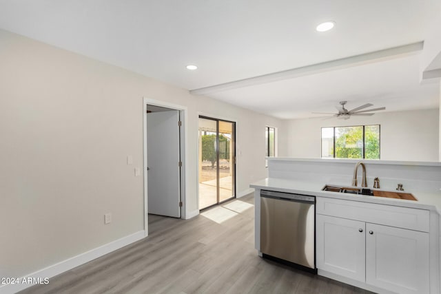 kitchen with stainless steel dishwasher, a healthy amount of sunlight, white cabinetry, and sink