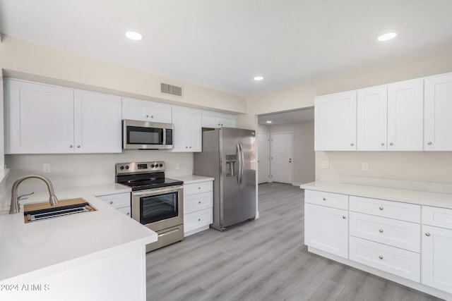 kitchen with light hardwood / wood-style floors, sink, white cabinetry, and stainless steel appliances