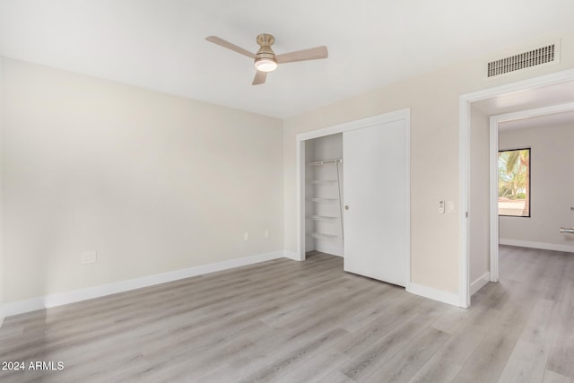 unfurnished bedroom featuring ceiling fan, a closet, and light hardwood / wood-style floors