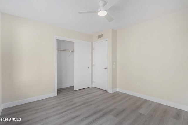 unfurnished bedroom with a closet, light hardwood / wood-style floors, and ceiling fan