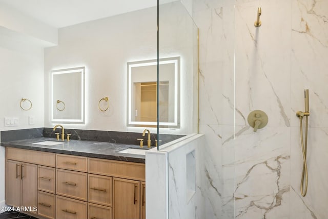 bathroom with tiled shower and vanity