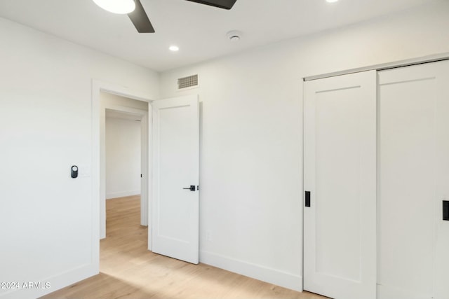 unfurnished bedroom featuring ceiling fan, a closet, and light hardwood / wood-style floors