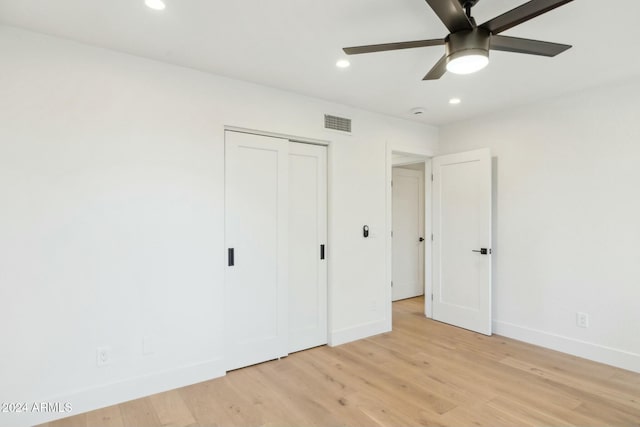 unfurnished bedroom with ceiling fan, a closet, and light wood-type flooring