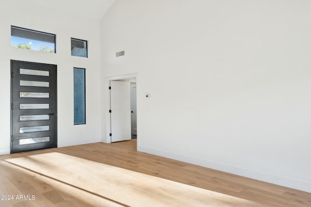 entrance foyer with wood-type flooring and high vaulted ceiling