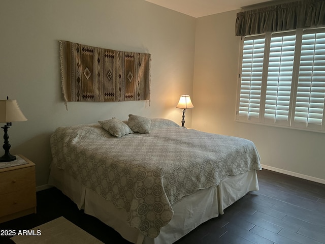 bedroom with multiple windows and dark wood-type flooring