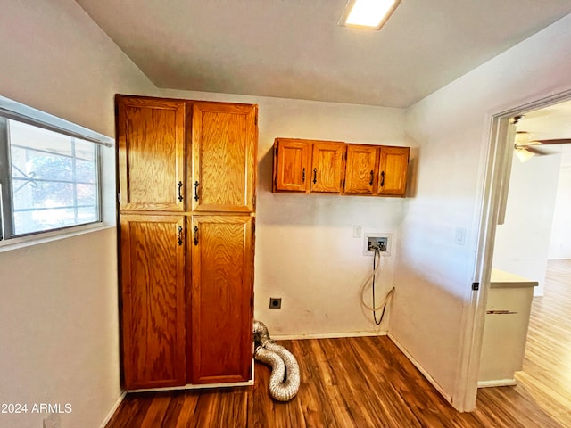 washroom with hardwood / wood-style floors, electric dryer hookup, and cabinets