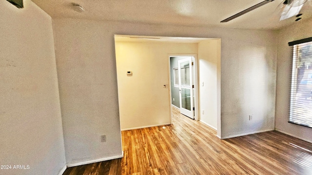 spare room with ceiling fan and light wood-type flooring