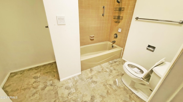 bathroom with tiled shower / bath combo and toilet