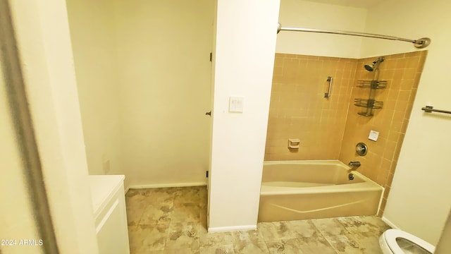 bathroom with tiled shower / bath combo and toilet