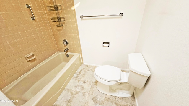 bathroom with toilet and tiled shower / bath