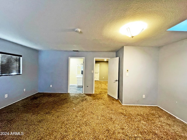 unfurnished bedroom featuring carpet and a textured ceiling