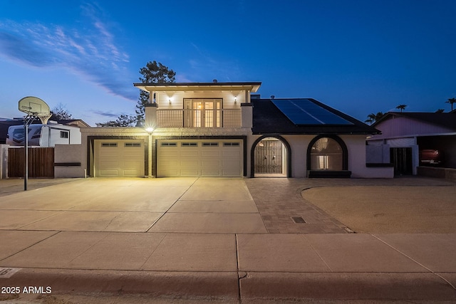 6216 W Poinsettia Dr, Glendale, AZ 85304 - view of front of home with concrete driveway, a balcony, solar panels, a garage, and stucco siding