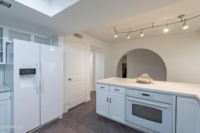 6216 W Poinsettia Dr, Glendale, AZ 85304 - kitchen featuring white appliances, dark tile patterned flooring, light countertops, and white cabinets
