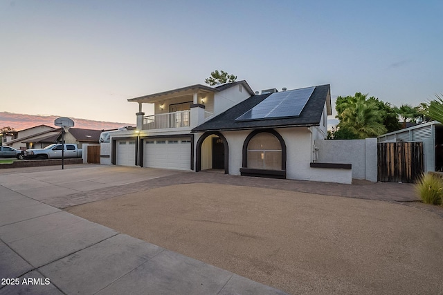 6216 W Poinsettia Dr, Glendale, AZ 85304 - view of front of home featuring a balcony, roof mounted solar panels, concrete driveway, fence, and a shingled roof