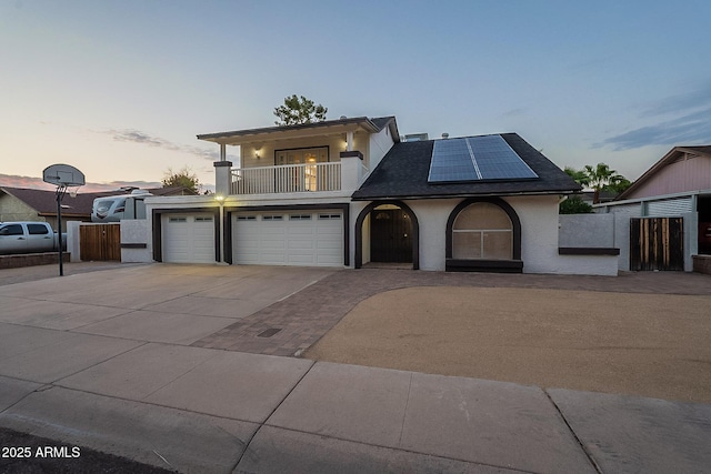 6216 W Poinsettia Dr, Glendale, AZ 85304 - view of front facade featuring a balcony, concrete driveway, solar panels, stucco siding, and fence