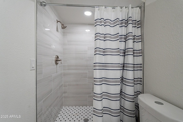 6216 W Poinsettia Dr, Glendale, AZ 85304 - bathroom featuring a tile shower, toilet, and a textured wall