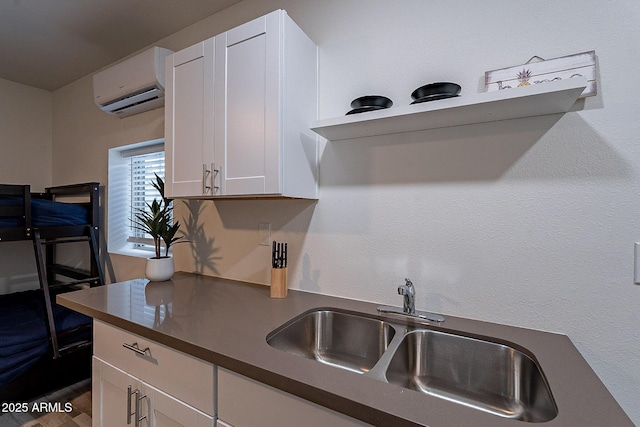 6216 W Poinsettia Dr, Glendale, AZ 85304 - kitchen with a sink, dark countertops, a wall unit AC, white cabinetry, and open shelves