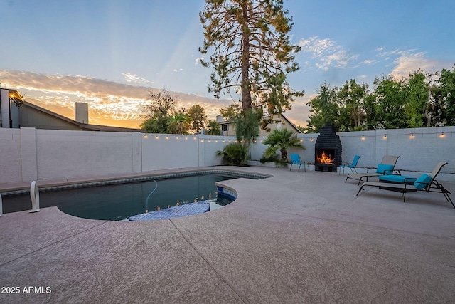 6216 W Poinsettia Dr, Glendale, AZ 85304 - view of swimming pool with a warm lit fireplace, a patio area, and a fenced backyard