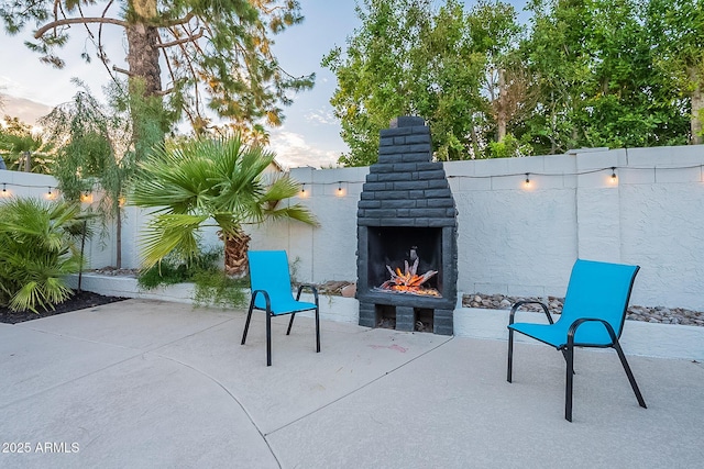 6216 W Poinsettia Dr, Glendale, AZ 85304 - view of patio / terrace featuring a warm lit fireplace and a fenced backyard