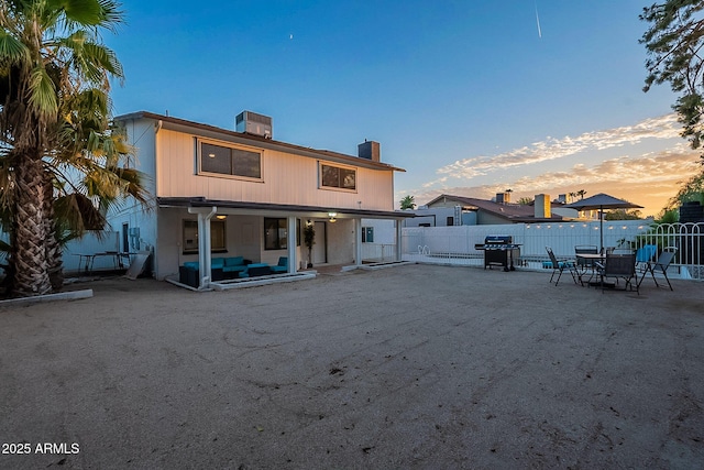 6216 W Poinsettia Dr, Glendale, AZ 85304 - back of house at dusk with a chimney, a patio area, a fenced backyard, and an outdoor living space
