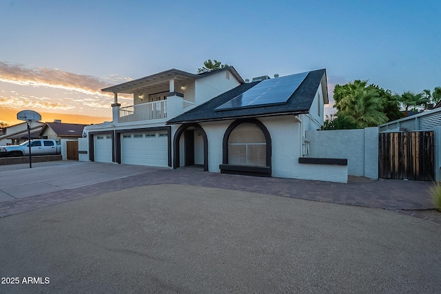 6216 W Poinsettia Dr, Glendale, AZ 85304 - view of front facade with a balcony, fence, concrete driveway, solar panels, and stucco siding