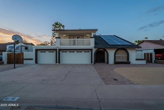 6216 W Poinsettia Dr, Glendale, AZ 85304 - view of front of property with a balcony, roof mounted solar panels, concrete driveway, an attached garage, and stucco siding
