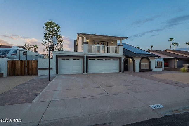 6216 W Poinsettia Dr, Glendale, AZ 85304 - view of front of home with concrete driveway, fence, a balcony, stucco siding, and an attached garage