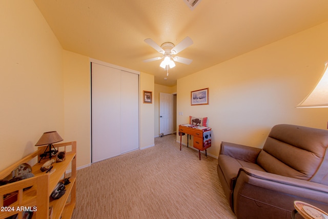 living area featuring ceiling fan and light colored carpet