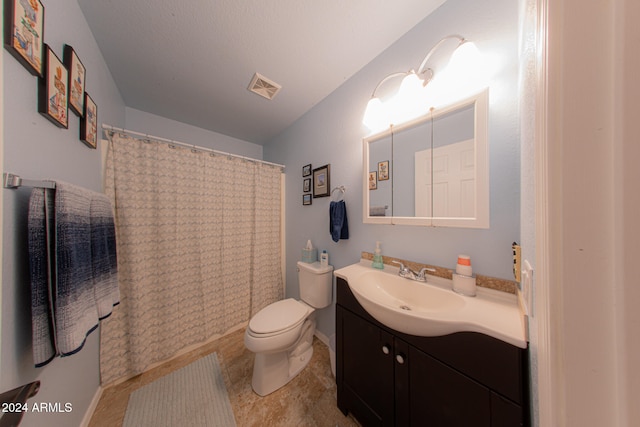 bathroom with tile patterned flooring, vanity, and toilet