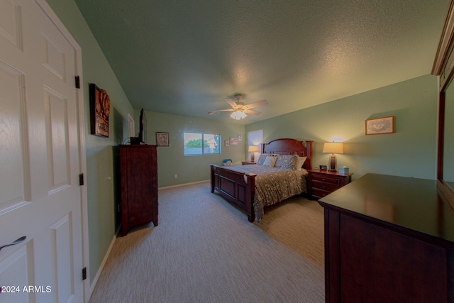 bedroom featuring ceiling fan, a textured ceiling, and light carpet