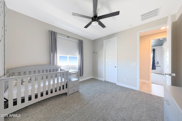 9750 E Radioactive Dr, Mesa, AZ 85212 - bedroom with light colored carpet, a ceiling fan, baseboards, and a crib