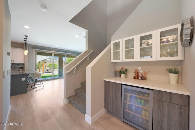 9750 E Radioactive Dr, Mesa, AZ 85212 - indoor dry bar with wine cooler, light wood-type flooring, stairs, tasteful backsplash, and recessed lighting