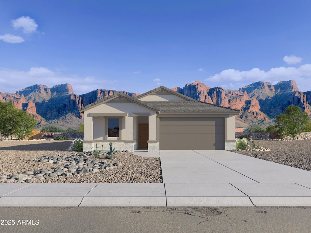 ranch-style house with stucco siding, a garage, driveway, a mountain view, and stone siding
