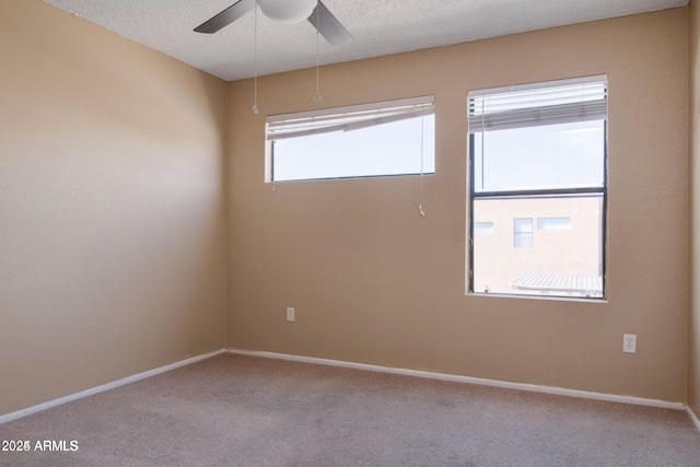 empty room featuring ceiling fan, a wealth of natural light, and light colored carpet