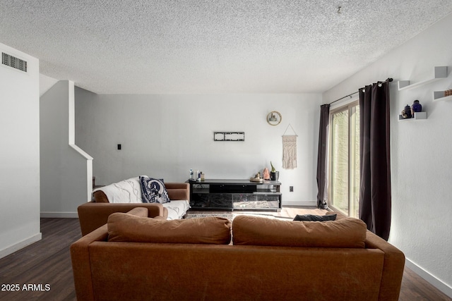 living room with dark hardwood / wood-style floors and a textured ceiling