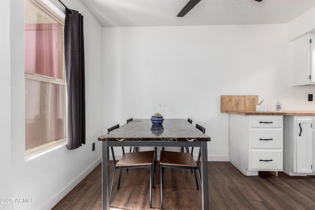 dining area with dark wood-type flooring, ceiling fan, and a textured ceiling