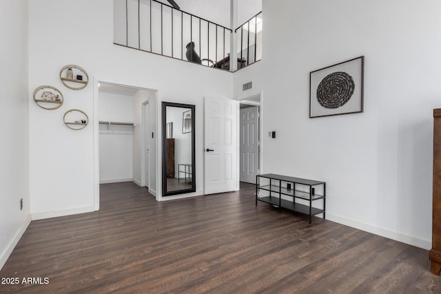 interior space with a high ceiling and dark wood-type flooring