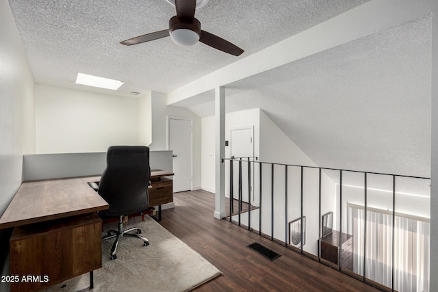 office featuring a skylight, dark wood-type flooring, and a textured ceiling