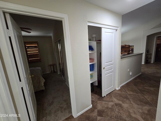 hallway with dark colored carpet