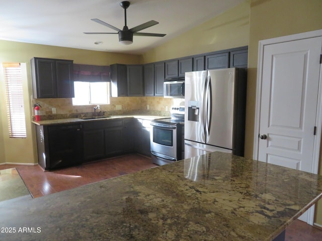 kitchen featuring appliances with stainless steel finishes, sink, dark hardwood / wood-style floors, stone countertops, and lofted ceiling